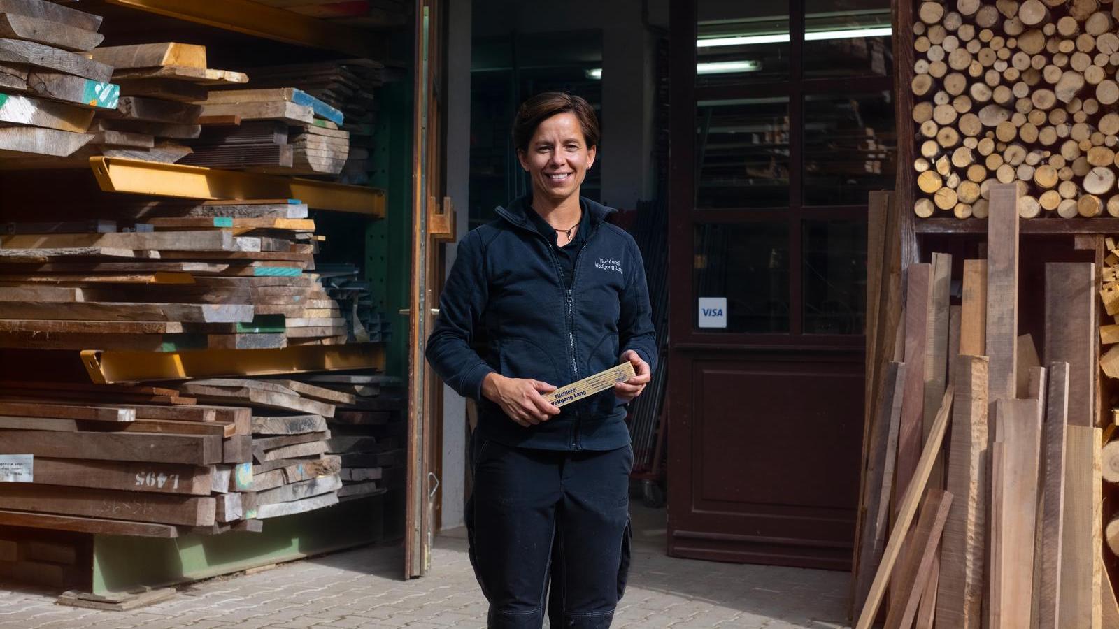 woman standing outside logging warehouse