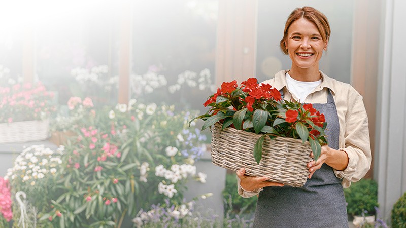 Smiling woman holding red flowers