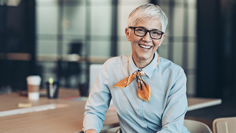 woman sat smiling at desk